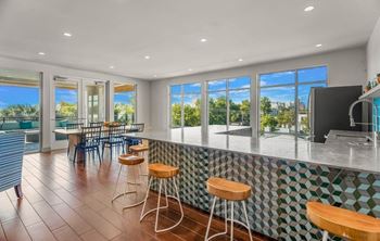 A kitchen with a bar area and a view of the outdoors.
